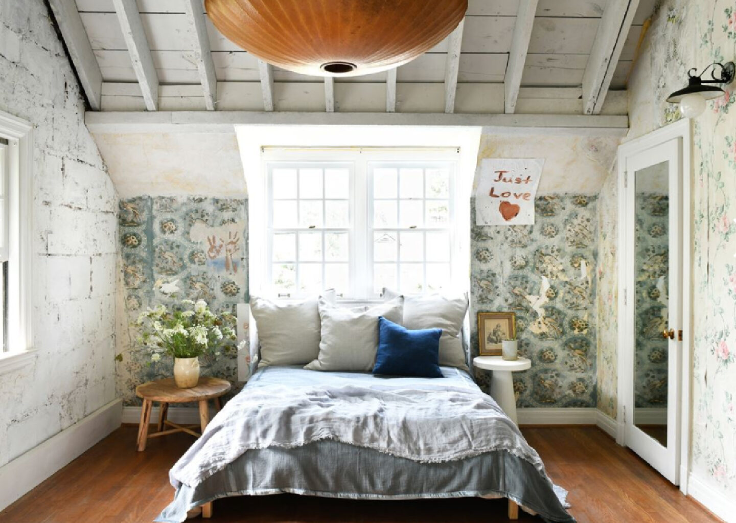 Leanne Ford designed bedroom with rough luxe walls and exposed rafters in her Pittsburgh guest cottage - photo by Erin Kelly for Pittsburgh Post Gazette. #modernrustic #vintagestyle