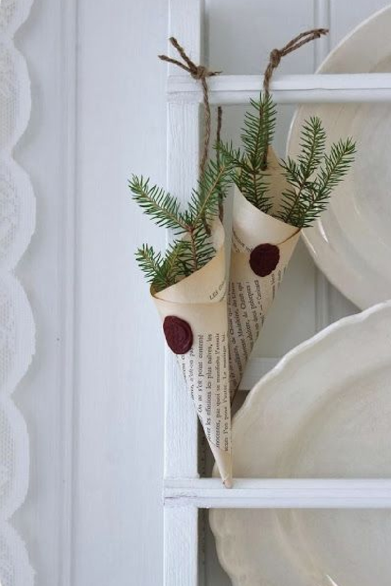 Charming book page cones with wax seal and greenery for Scandi simple Christmas decor on a platerack with white vintage ironstone - Lillablanka.