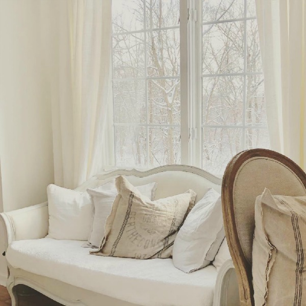 French Nordic style room with settee and vintage grain sack pillows - Hello Lovely Studio. #frenchnordic #frenchcountry #allwhitedecor