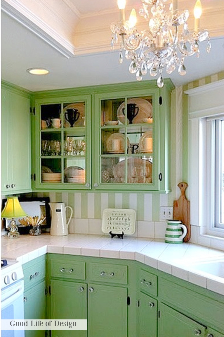 Charming green kitchen cabinets and stripe wallpaper in a traditional style kitchen reflecting Grandmillennial style - Good Life of Design.