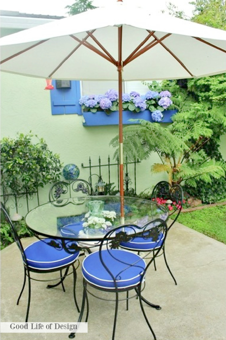 Cornflower blue and spring green colors on a patio with charming dining set and window box with hydrangea - Good Life of Design. #grandmillennialstyle #dining