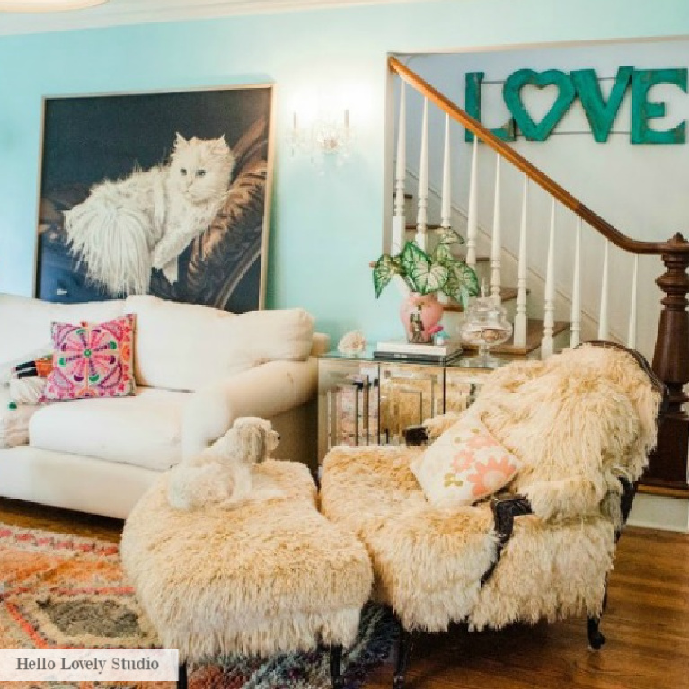 Turquoise wall in a charming Grandmillennial living room with vintage painting of white cat - Jenny Sweeney design on Hello Lovely. #grandmillennial #livingroom