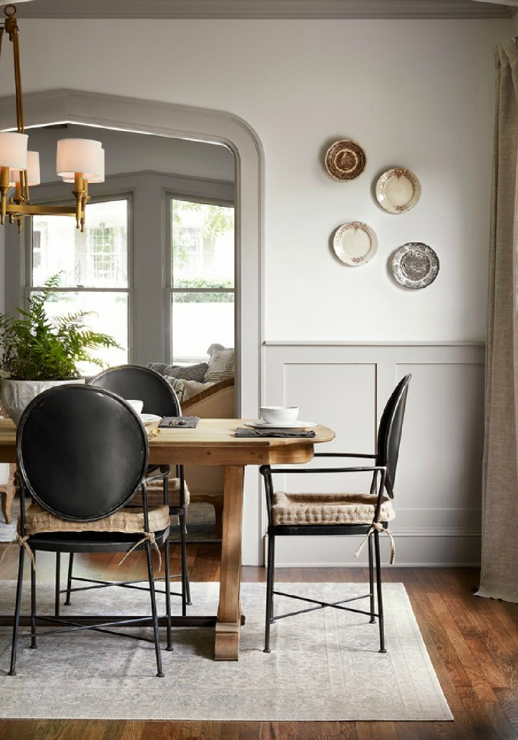 Plates on dining room wall. Come get inspired by Tranquil and Timeless Tudor Design Details From a Serene 1920s Texas Cottage renovated on HGTV's Fixer Upper by Chip and Joanna and known as the Scrivano House. #fixerupper #scrivano #cottagestyle #interiordesign #greytrim #serenedecor