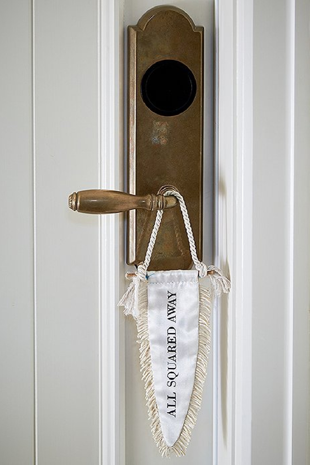 The owners worked with Cory Schifler of Urchin Workshop to design cheeky accessories for the space, including these doorknob flags—a creative take on “Please make up this room.”