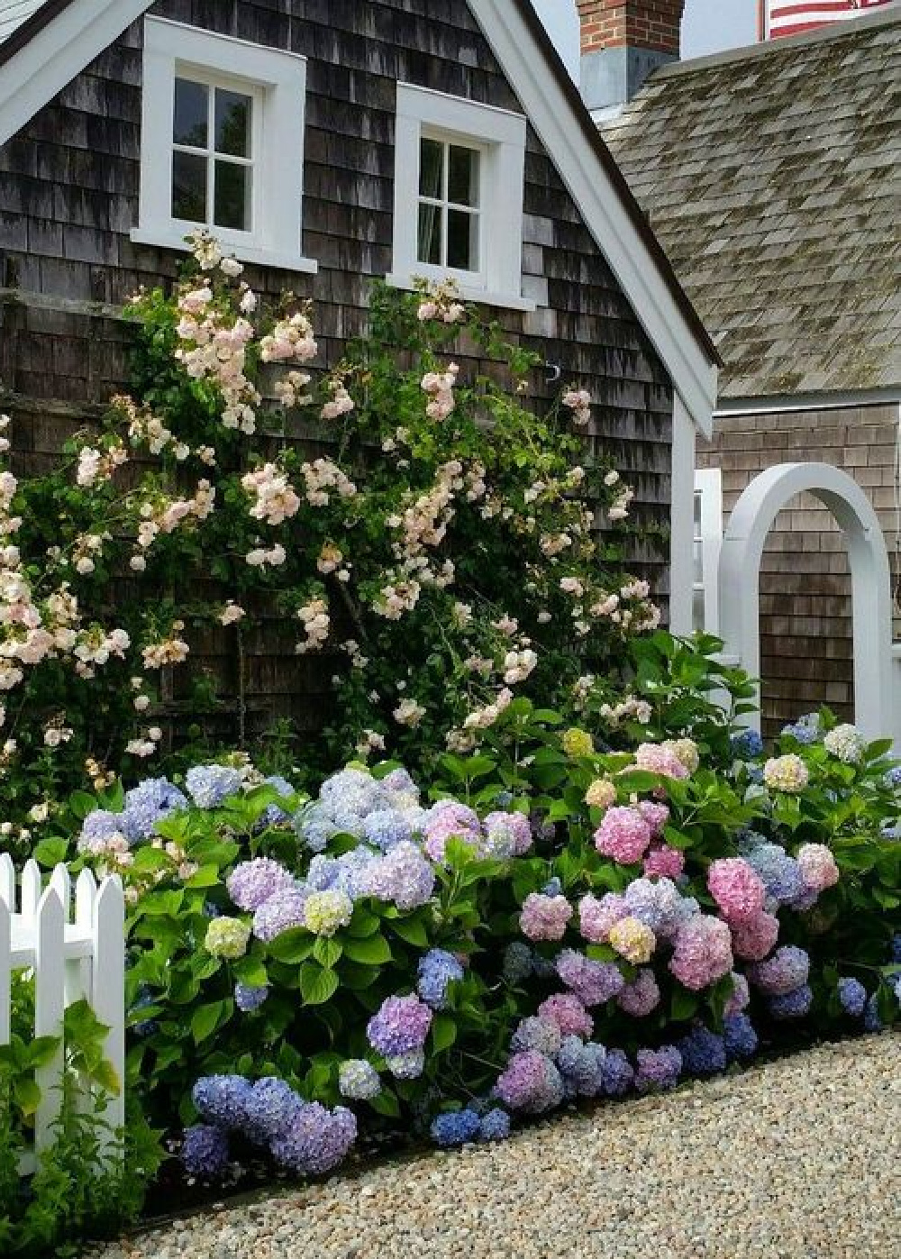 Nantucket cottage with flowers in bloom. COME TOUR MORE Nantucket Style Chic & Summer Vibes! #nantucket #interiordesign #designinspiration #summerliving #coastalstyle