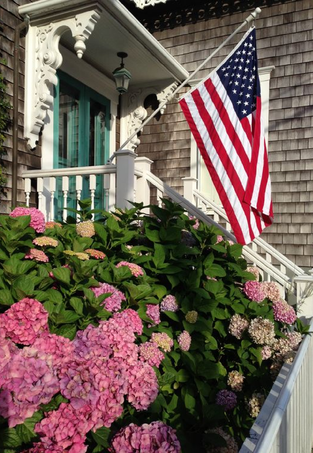 North Water Street, Nantucket with pink hydrangea in bloom and American flag. COME TOUR MORE Nantucket Style Chic & Summer Vibes! #nantucket #interiordesign #designinspiration #summerliving #coastalstyle