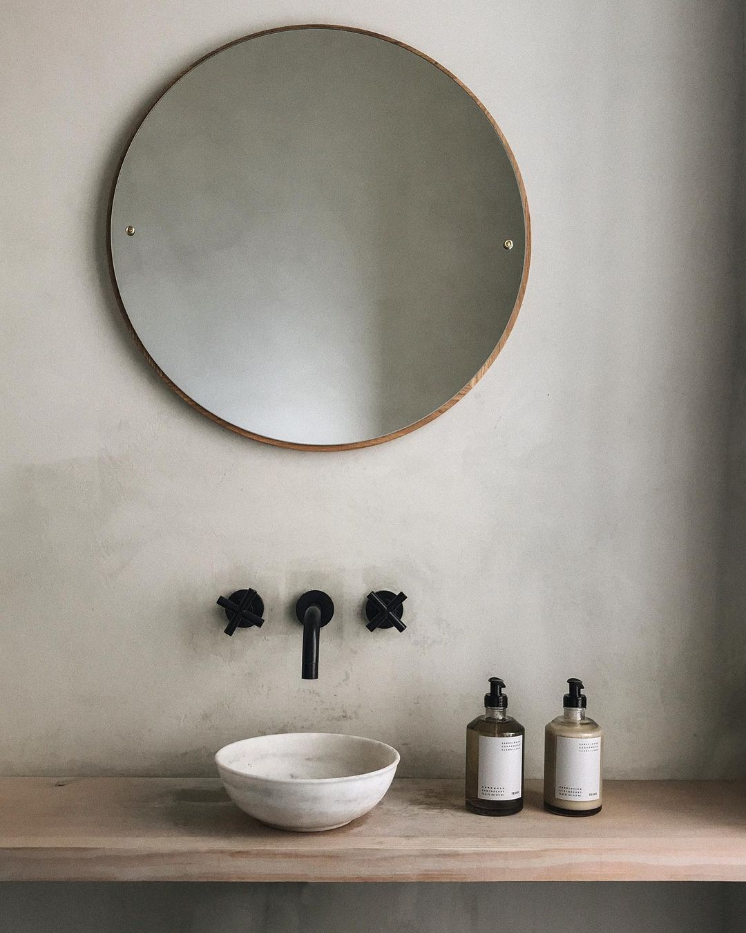 Serene, minimal, rustic bathroom design with vessel sink and round mirror - @framacph.