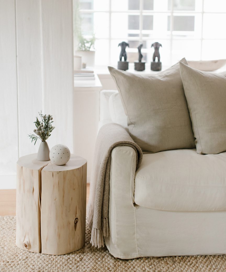 Jenni Kayne cedar stump with linen sofa in a lovely tranquil natural luxe space.