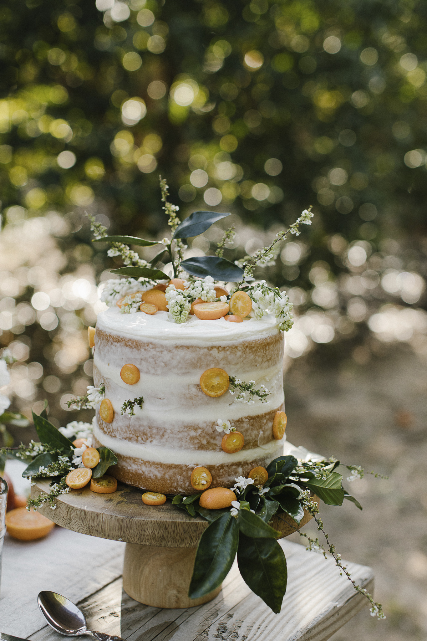 A layered naked cake on a rustic wood table in Jenni Kayne's PACIFIC NATURAL (Rizzoli, 2019).