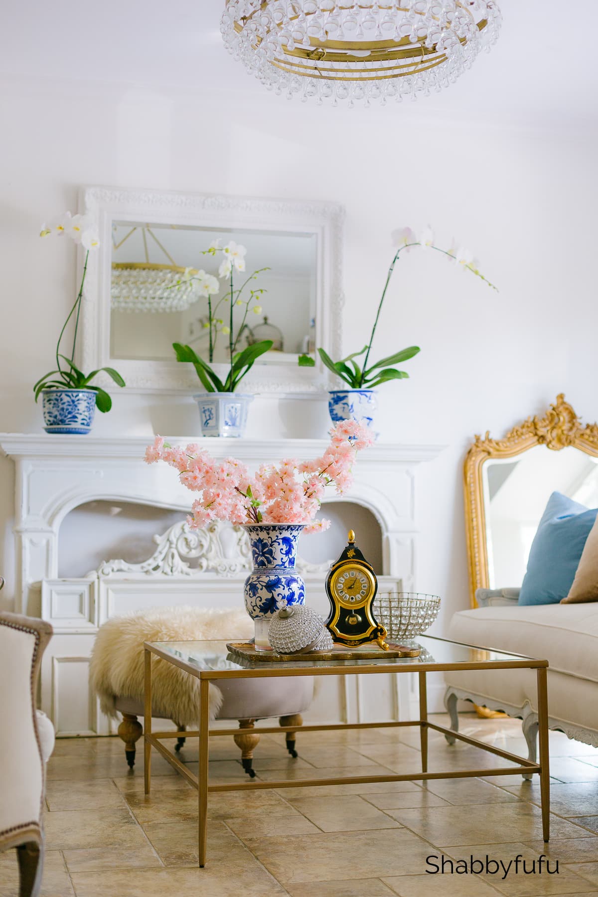 Blue and white porcelain, a French fireplace, and traditional furnishings in a living room with Grandmillennial style - Shabbyfufu. #grandmillennialstyle #livingroom #traditionaldecor