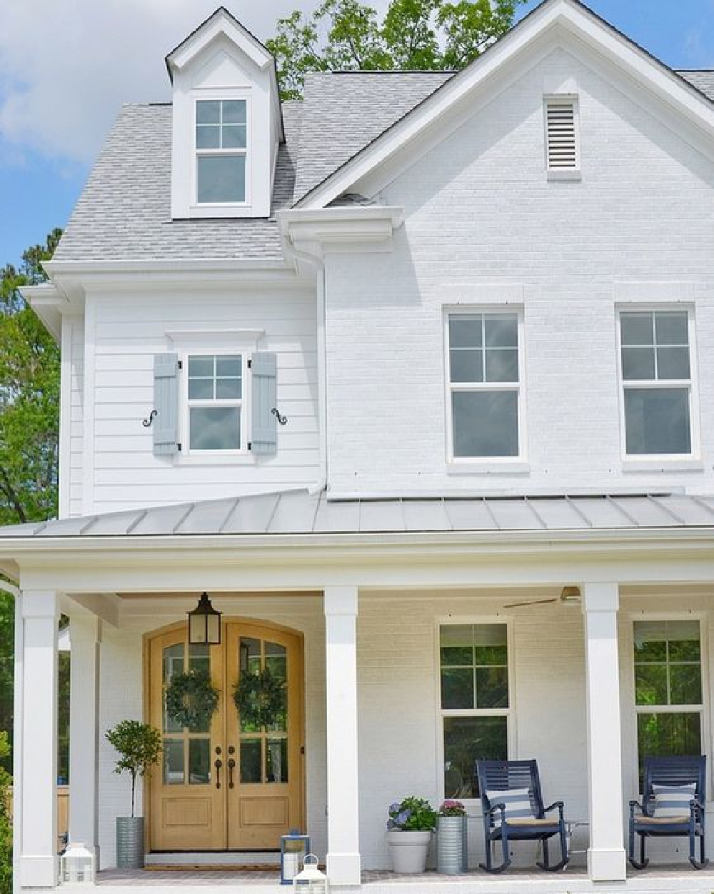 Sherwin Williams Extra White paint color on a gorgeous modern farmhouse with blue shutters - CrissyMarieBlog. #whitehouses #swextrawhite #whitepaintcolors