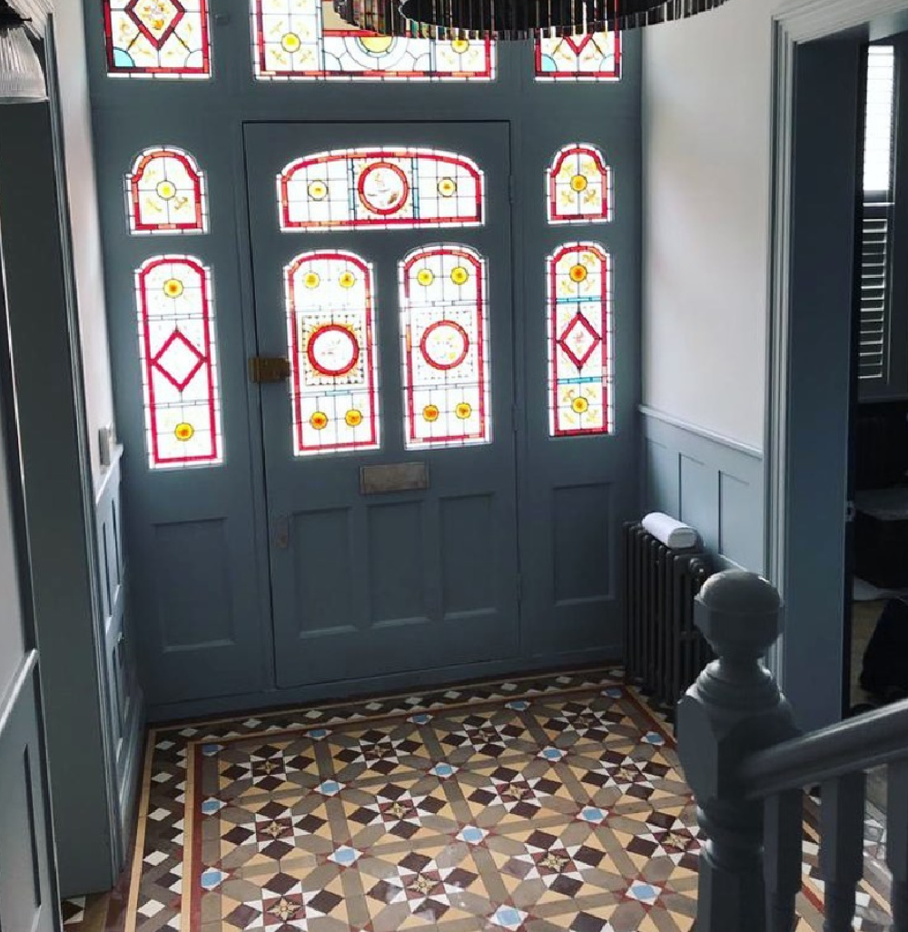 Victorian home entry with encaustic tile flooring, stained glass, and deep blue millwork - Victorian Tiling Wales.