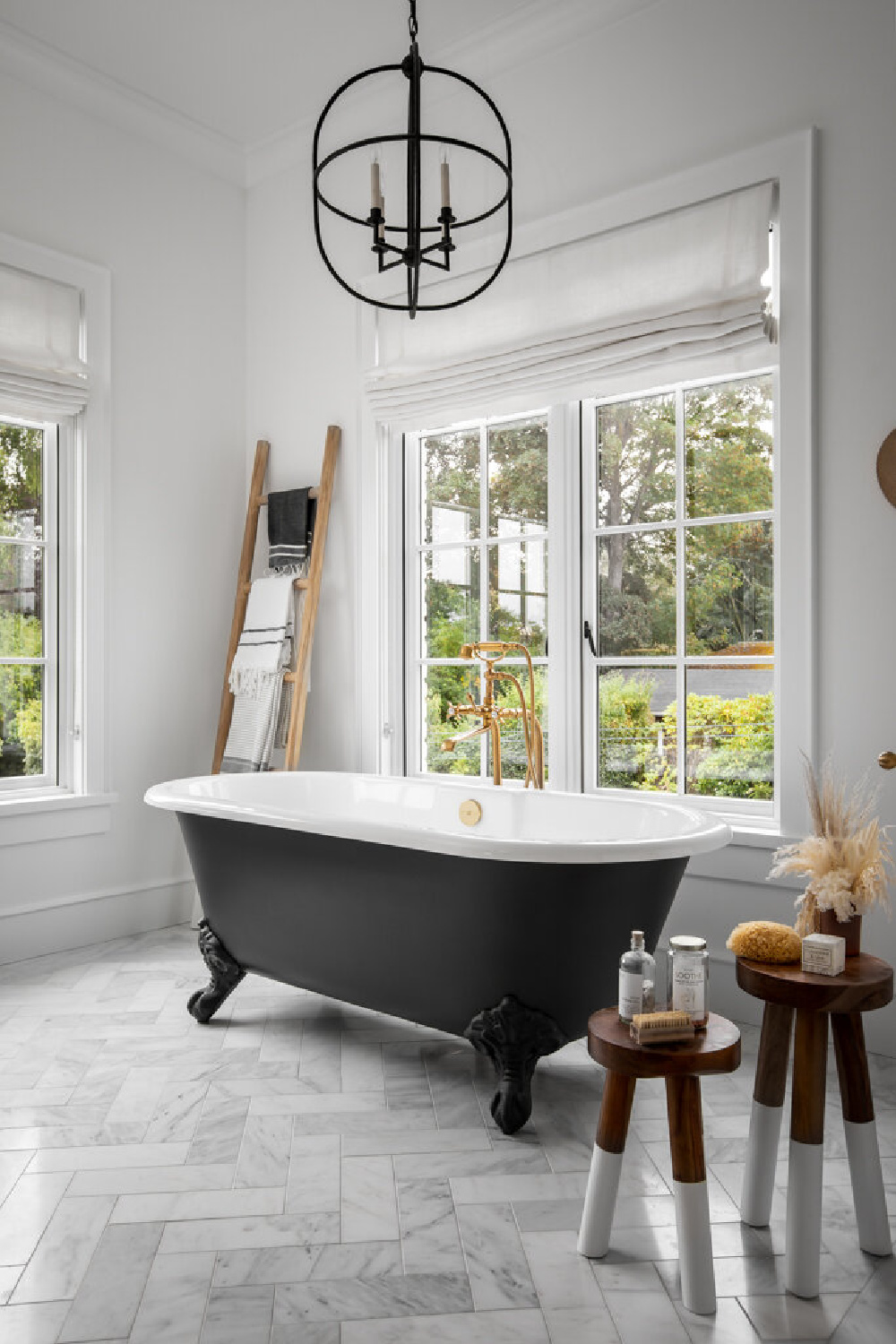 Beautiful French country bath with clawfoot tub painted black, herringbone marble tile, and ladder with Turkish towels - Jenny Martin Design. #modernfrench #bathroomdesign