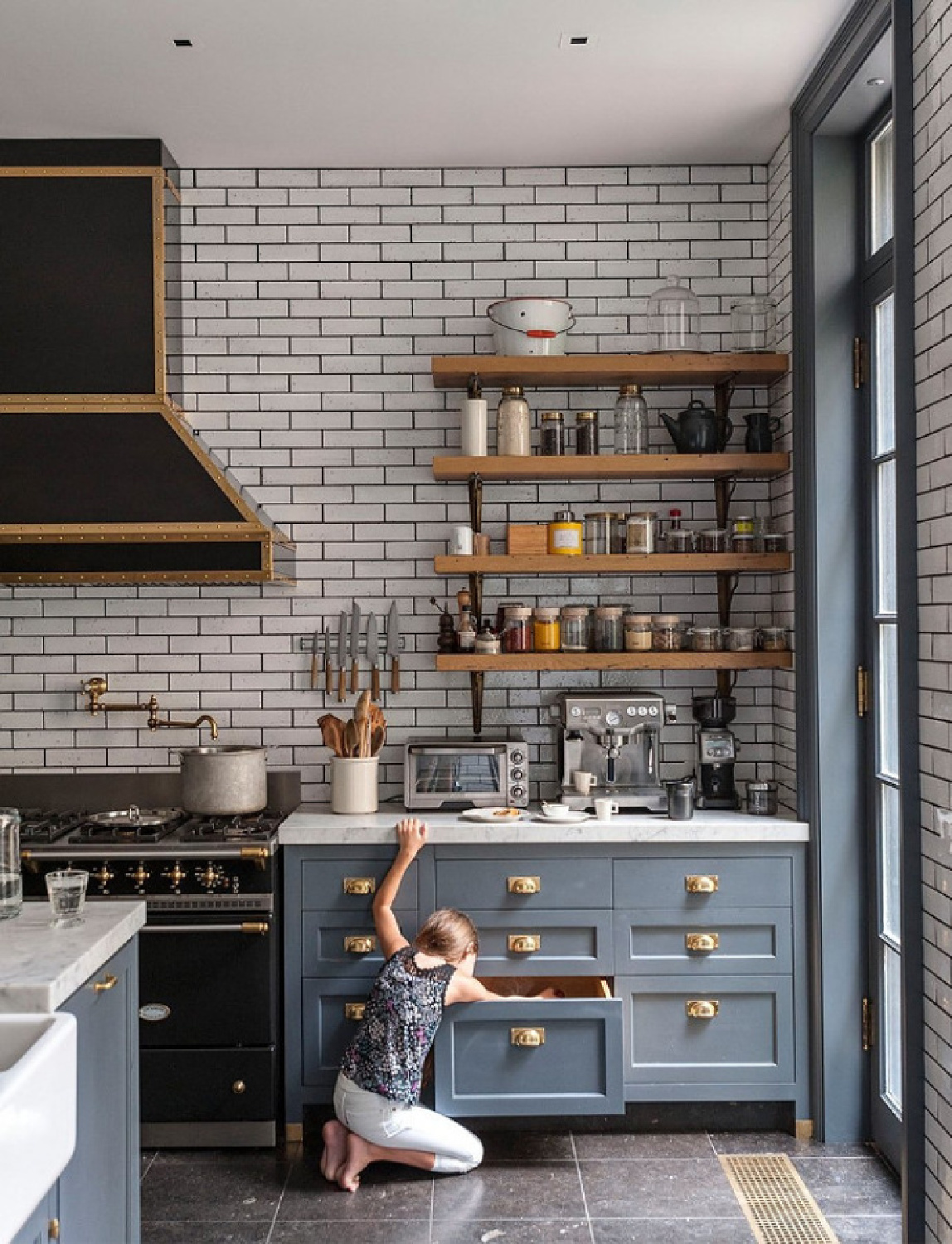 Amazing grey blue pained Shaker cabinets in a NY townhouse kitchen with open shelves, subway tile, brass hardware, and black Lacanche range. Ali Cayne of Haven Kitchen. #graykitchen #greyblue #kitchendesign #openshelves #lacanche #subwaytile #graycabinets #brasshardware