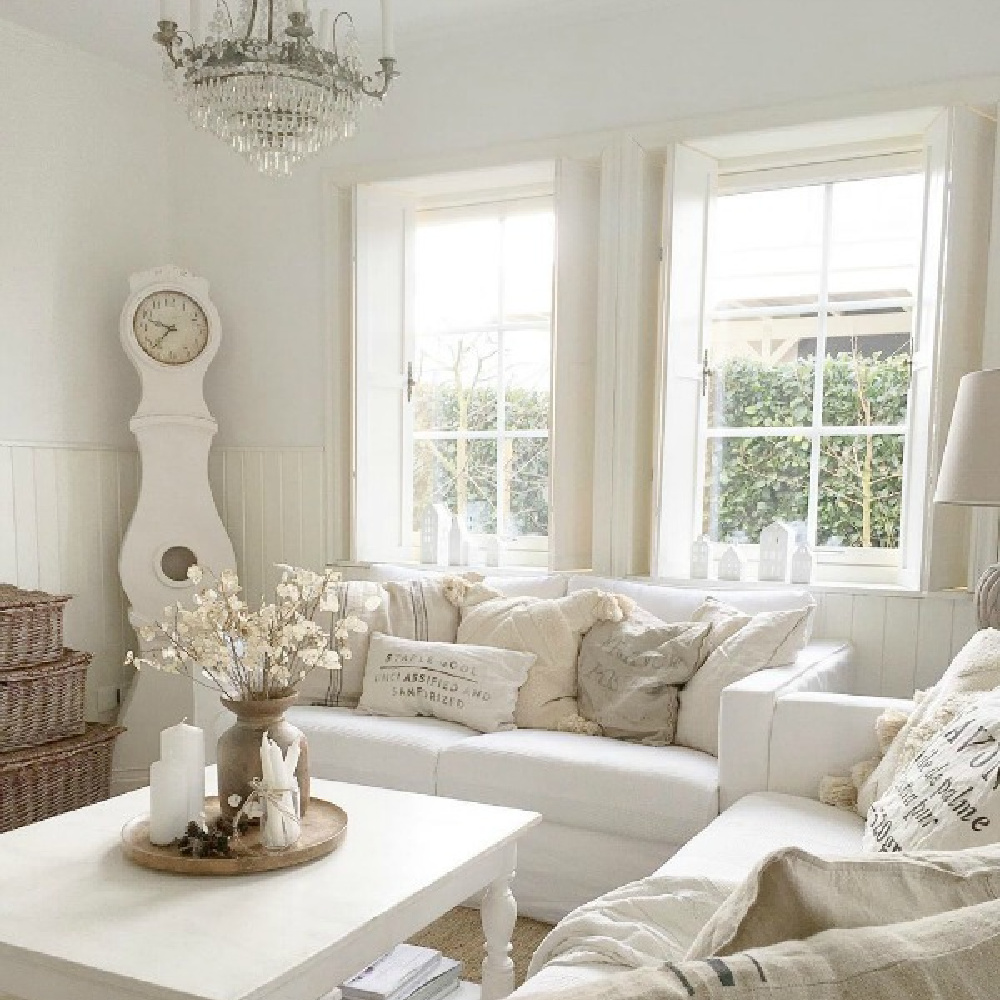 White on white French Nordic style living room with Mora clock and pale accessories - Villa Jenal.