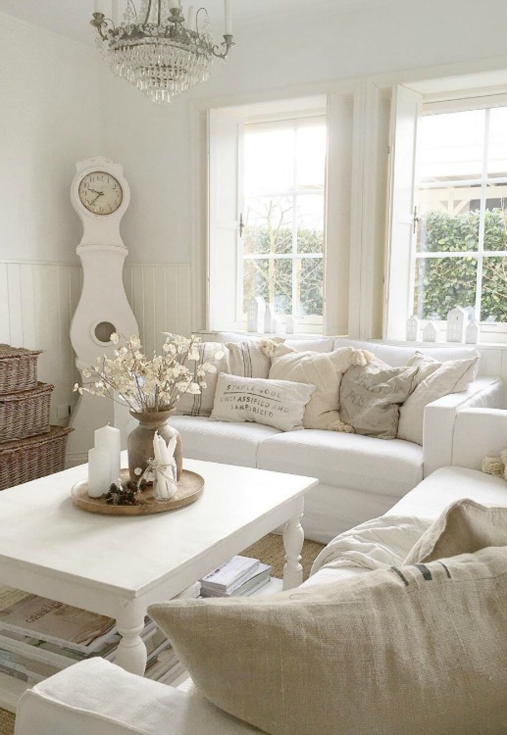 White on white French Nordic style living room with Mora clock and pale accessories - Villa Jenal.