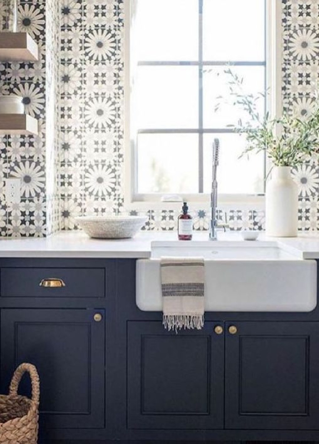 Stunning blue and white graphic tiles on sink wall of a kitchen with navy blue cabinets and farm sink. Come see 36 Best Beautiful Blue and White Kitchens to Love! #blueandwhite #bluekitchen #kitchendesign #kitchendecor #decorinspiration #beautifulkitchen