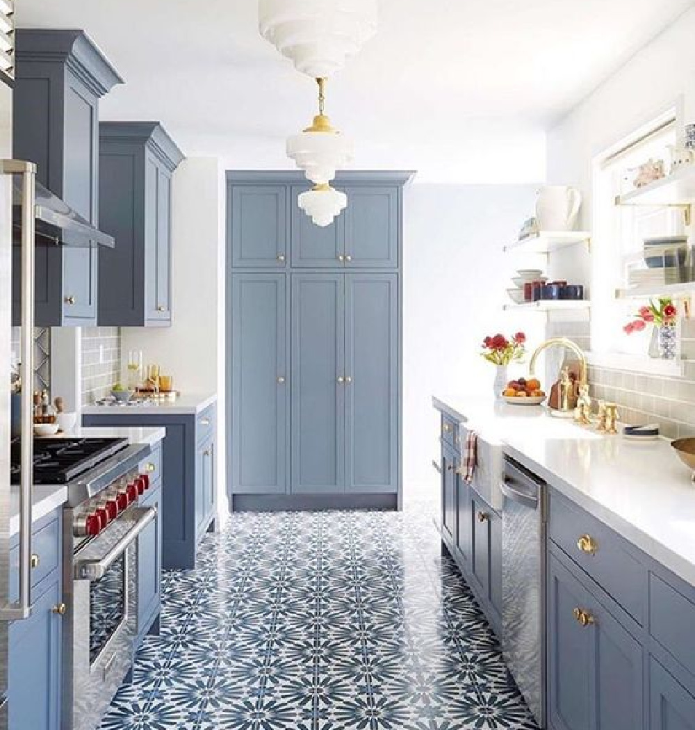Whitney Parknson designed blue and white vintage modern kitchen with bold cheerful tiled floor and blue-trey painted cabinets with brass hardware.