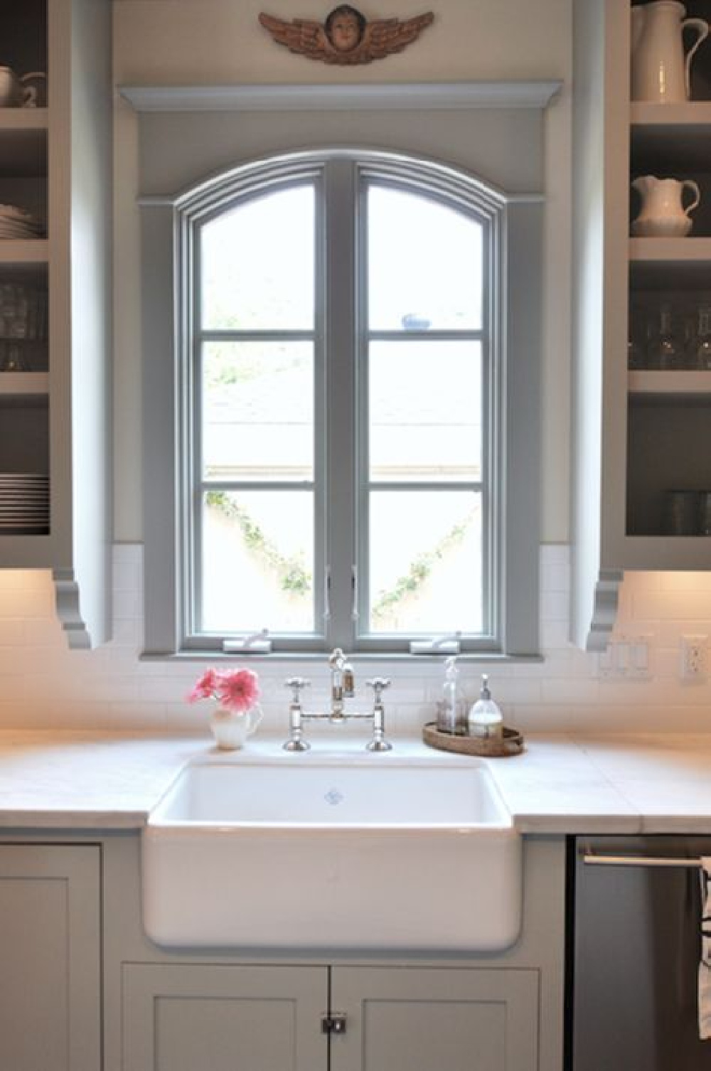 Beautiful arched window over farm sink in blue grey kitchen by Sally Wheat.