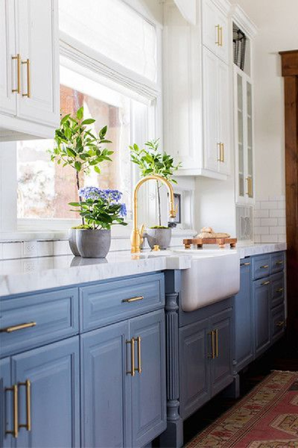 Blue modern farmhouse kitchen with farm sink and brass hardware - Becki Owens.