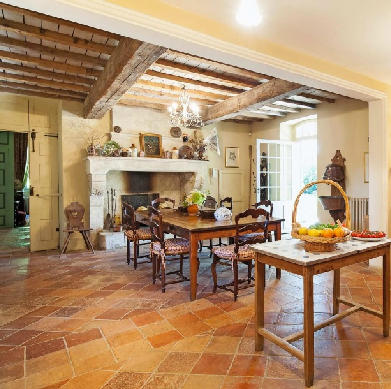 Cheerful and traditional with terracotta, green, and bright blue accents, this Provence kitchen with work table boasts timeless charm - Haven In. #frenchcountry #kitchens