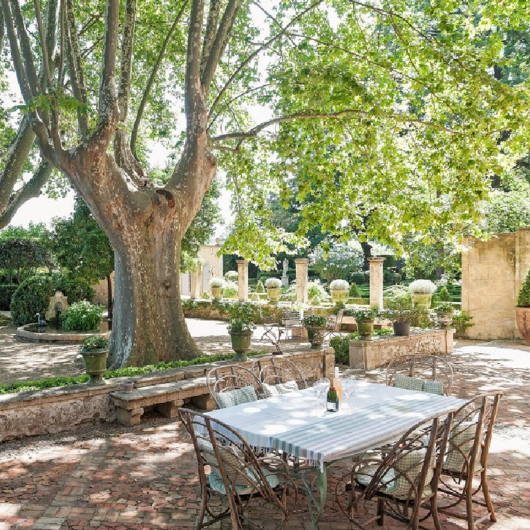 French formal gardens and tree shaded outdoor dining with pea gravel - see more of this Stunning French Château Near St-Rémy-de-Provence by Haven In. #frenchgarden #frenchcountry #frenchchateau