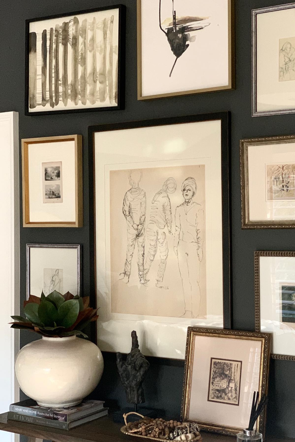 Gorgeous gallery wall painted Benjamin Moore Iron Mountain provides a lovely contrast with framed art with white mats - Sherry Hart. #benjaminmoore #ironmountain #paintcolors