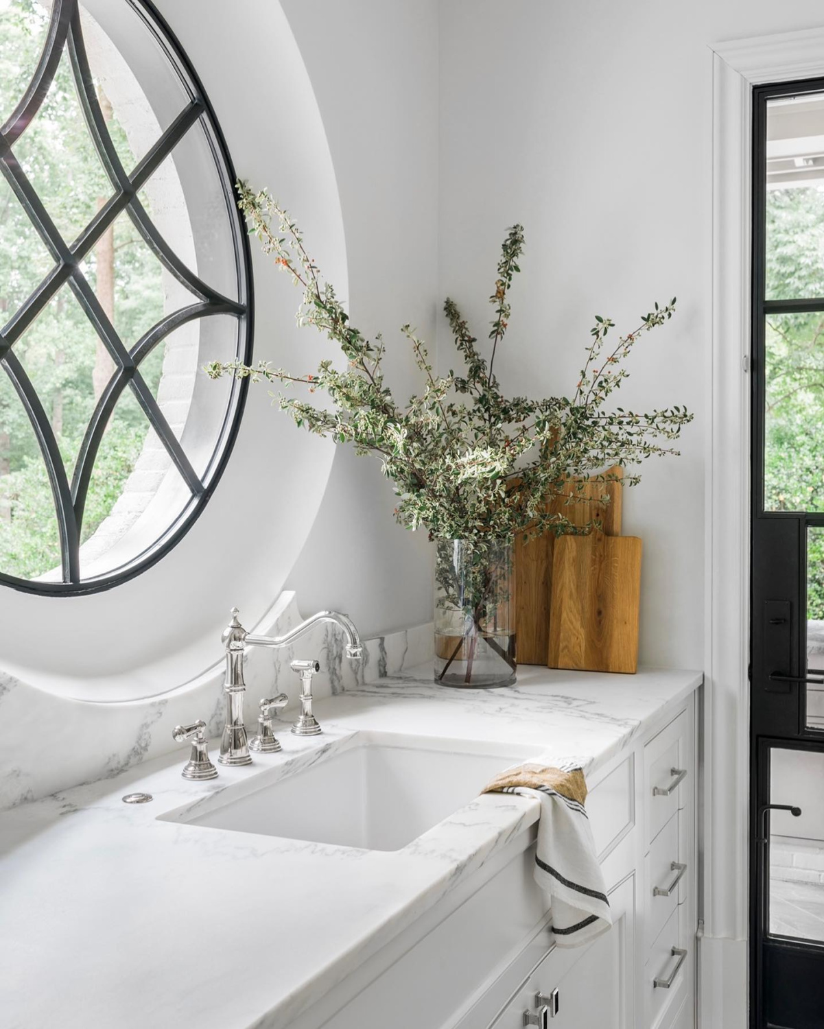 A gloriously elegant white kitchen with iron door and decorative window - Ladisic Fine Homes and Sherry Hart. #whitekitchens #elegantkitchens #irondoor #decorativewindow