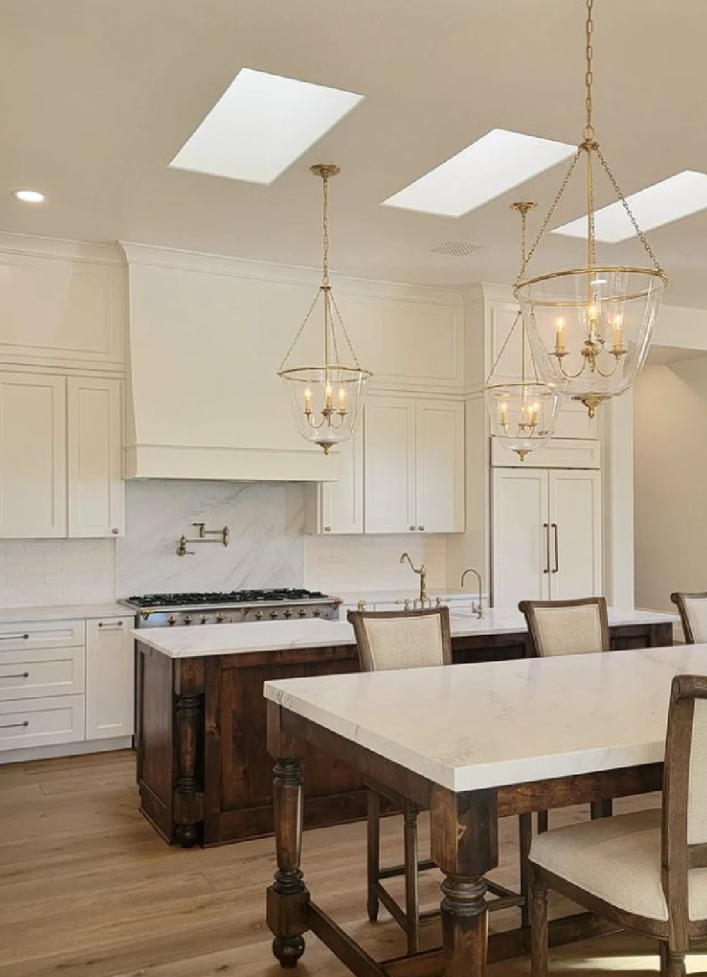 Elegant white French inspired kitchen with skylights, lofty ceilings, and rich details - TheFrenchNestCoInteriorDesign. #frenchkitchens