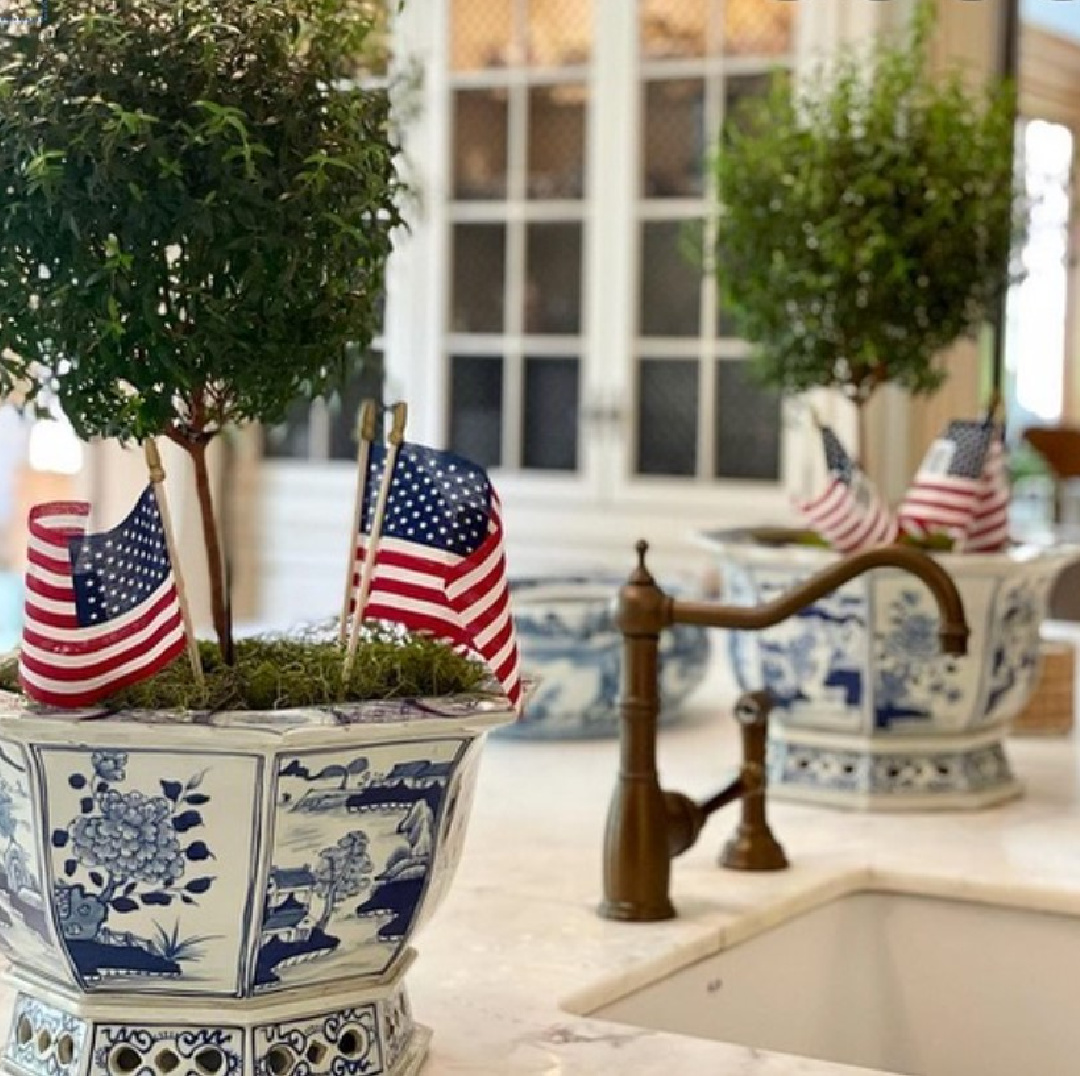 The Enchanted Home: 4th of July topiaries in Tina's French kitchen with blue and white porcelain, marble countertops, and limestone tile flooring. #theenchantedhome