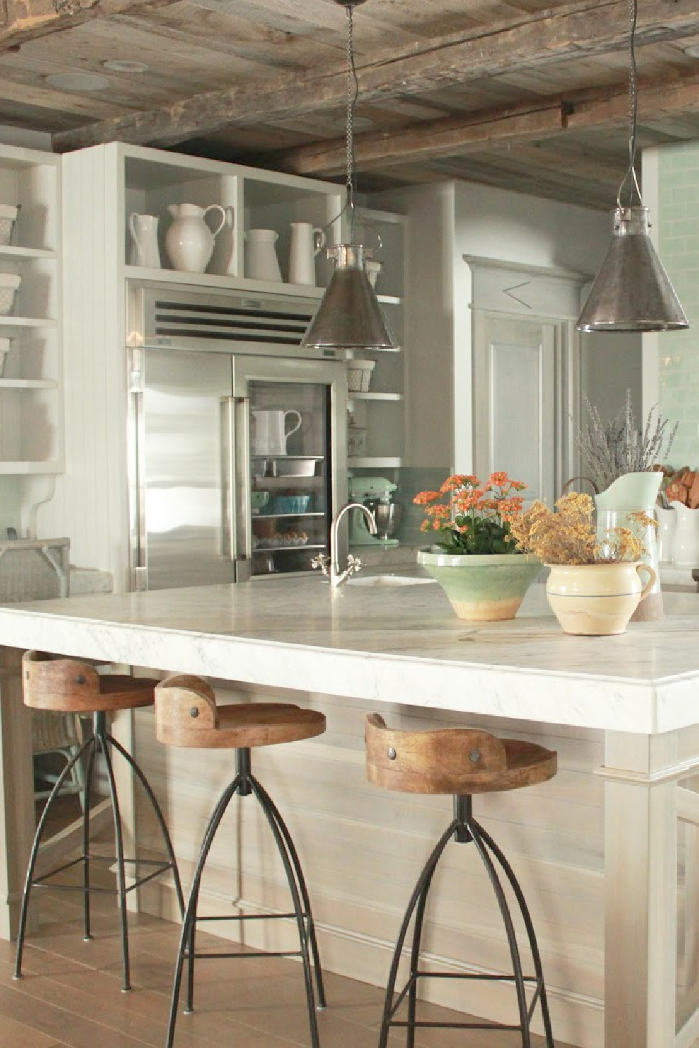 Magnificent Gustavian French kitchen in stone cottage with rustic interiors, reclaimed wood ceilings, blue-grey, green, and collected European antiques. Designed by Desiree Ashworth. Find ideas for grey, blue, and green paint colors.