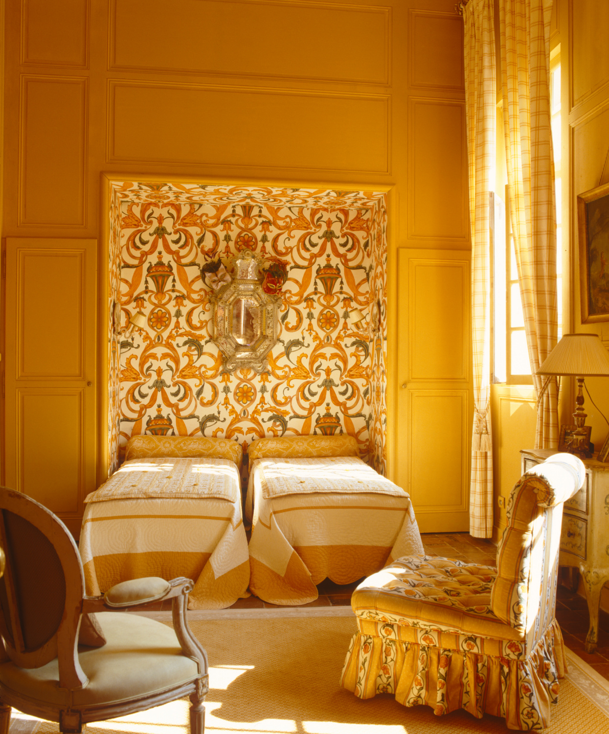 A pair of single beds in this high ceilinged panelled bedroom is fitted into an alcove upholstered in a Bracquenie document Indian cotton. French provincial style in Shauna Varvel's PROVENCE STYLE. #interiordesign #frenchcountry #oldworldstyle