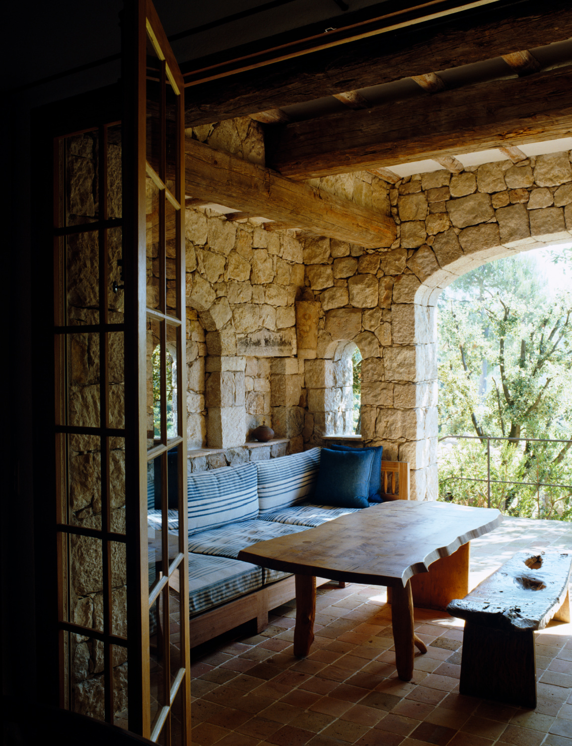 Rugged stone walls and beams comprise a Provence outdoor living area with rustic furnishings. Shauna Varvel's PROVENCE STYLE. #frenchprovincial #interiordesign #frenchcountry #oldworldstyle