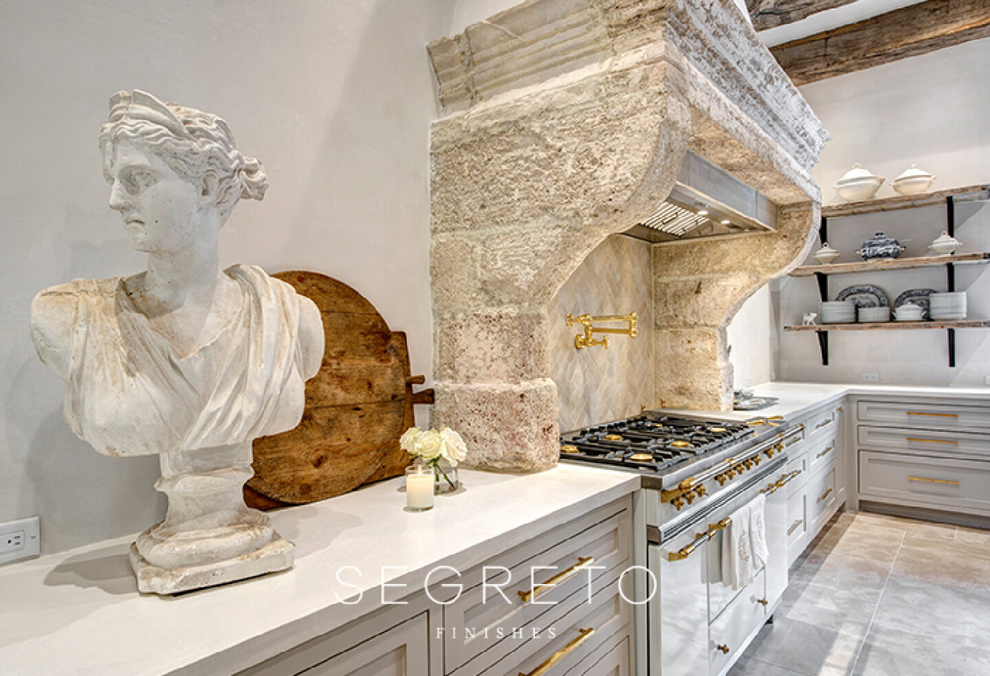 Pale tones in a French kitchen with impeccable plaster finishes, antiques and reclaimed materials - Segreto Finishes. #frenchkitchens #chateaudomingue #stonehood