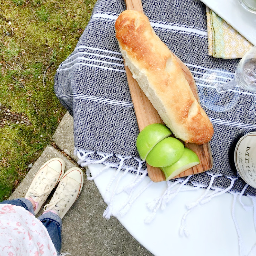 French baguette and delicious snacks on a Parisian bistro table at home - Hello Lovely.