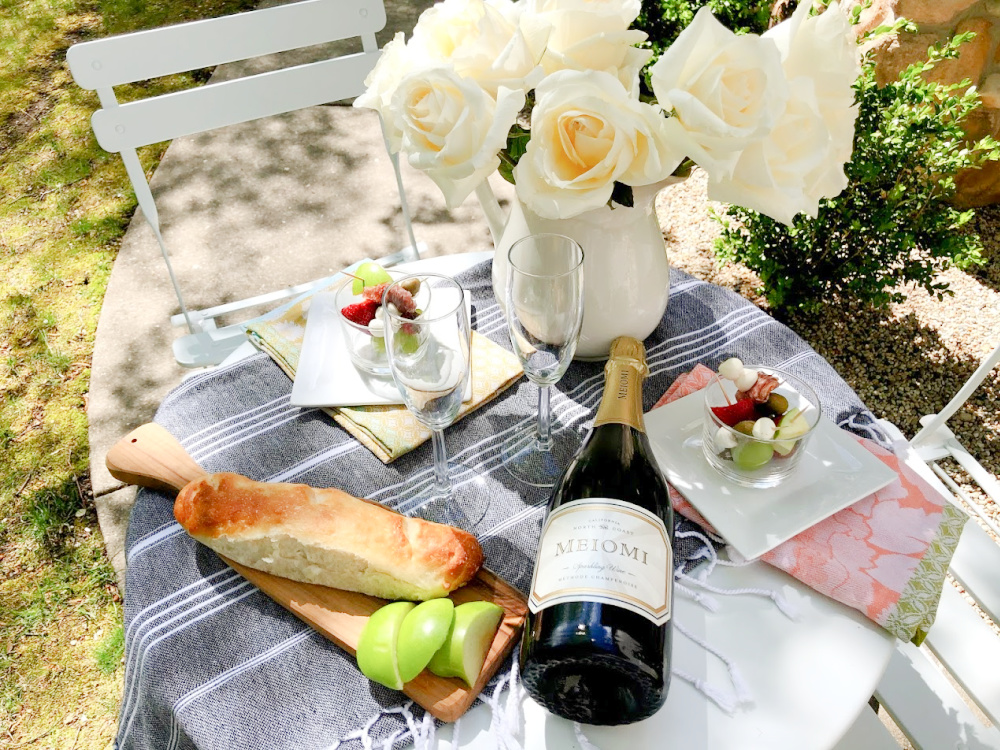 Champagne, jarcuterie and baguette on a charming French cafe dining table in garden - Hello Lovely Studio. #jarcuterie #frenchpicnic #frenchaesthetic #outdoordining