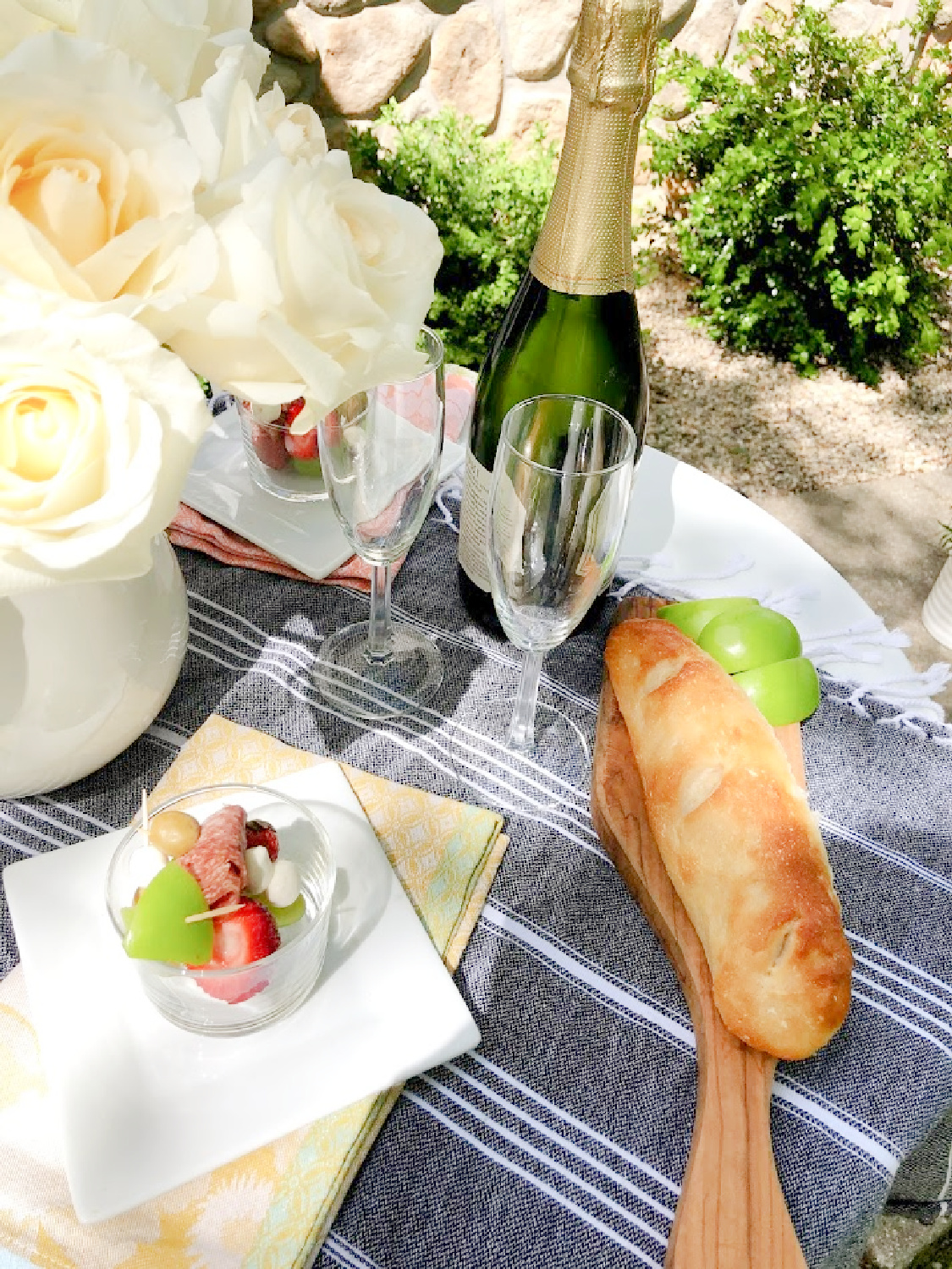 Jarcuterie and baguette on a charming round French cafe dining table in the garden - Hello Lovely Studio. #jarcuterie #frenchpicnic #frenchaesthetic #outdoordining