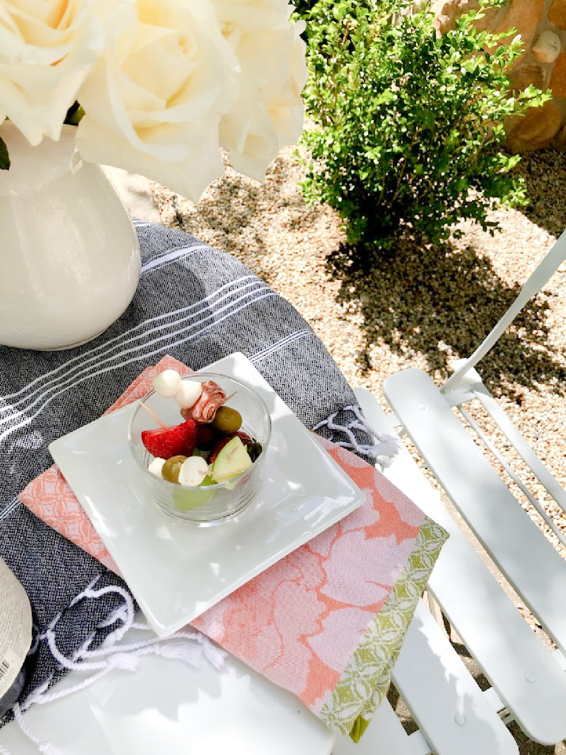 Jarcuterie is served on a charming French cafe dining table in the garden - Hello Lovely Studio. #jarcuterie #frenchpicnic #frenchaesthetic #outdoordining