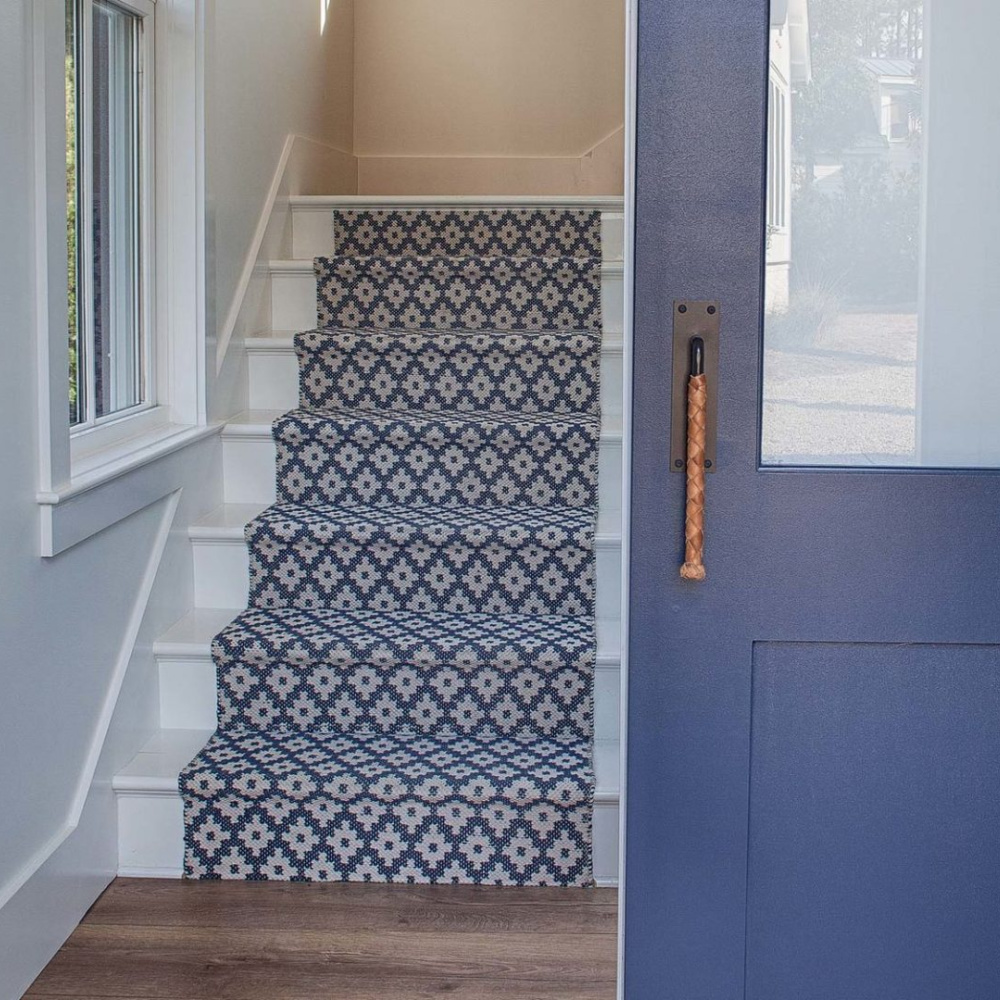 Blue stair runner and door painted BM Andes Summit. Board and batten coastal cottage in Palmetto Bluff with modern farmhouse interior design by Lisa Furey. #bluedoor #bluecarpet #interiordesign #coastalstyle