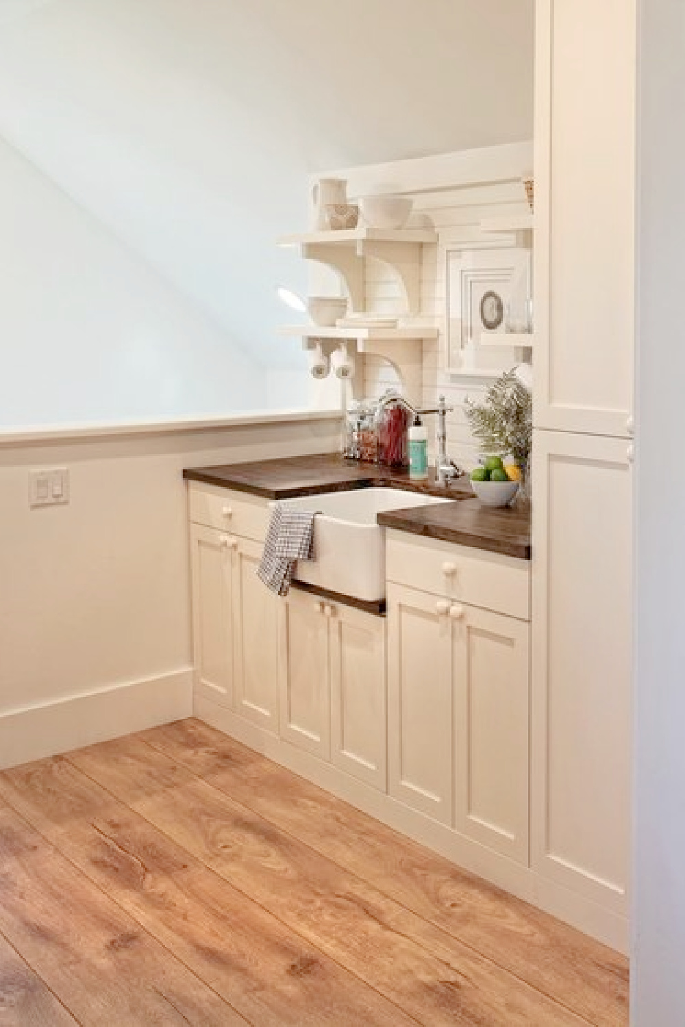 Kitchen with farm sink, wide plank wood flooring, built in captains beds and French doors to deck in carriage house with coastal and Shaker style. Design by Lisa Furey. #coastalstyle #modernfarmhouse #carriagehouse #interiordesign