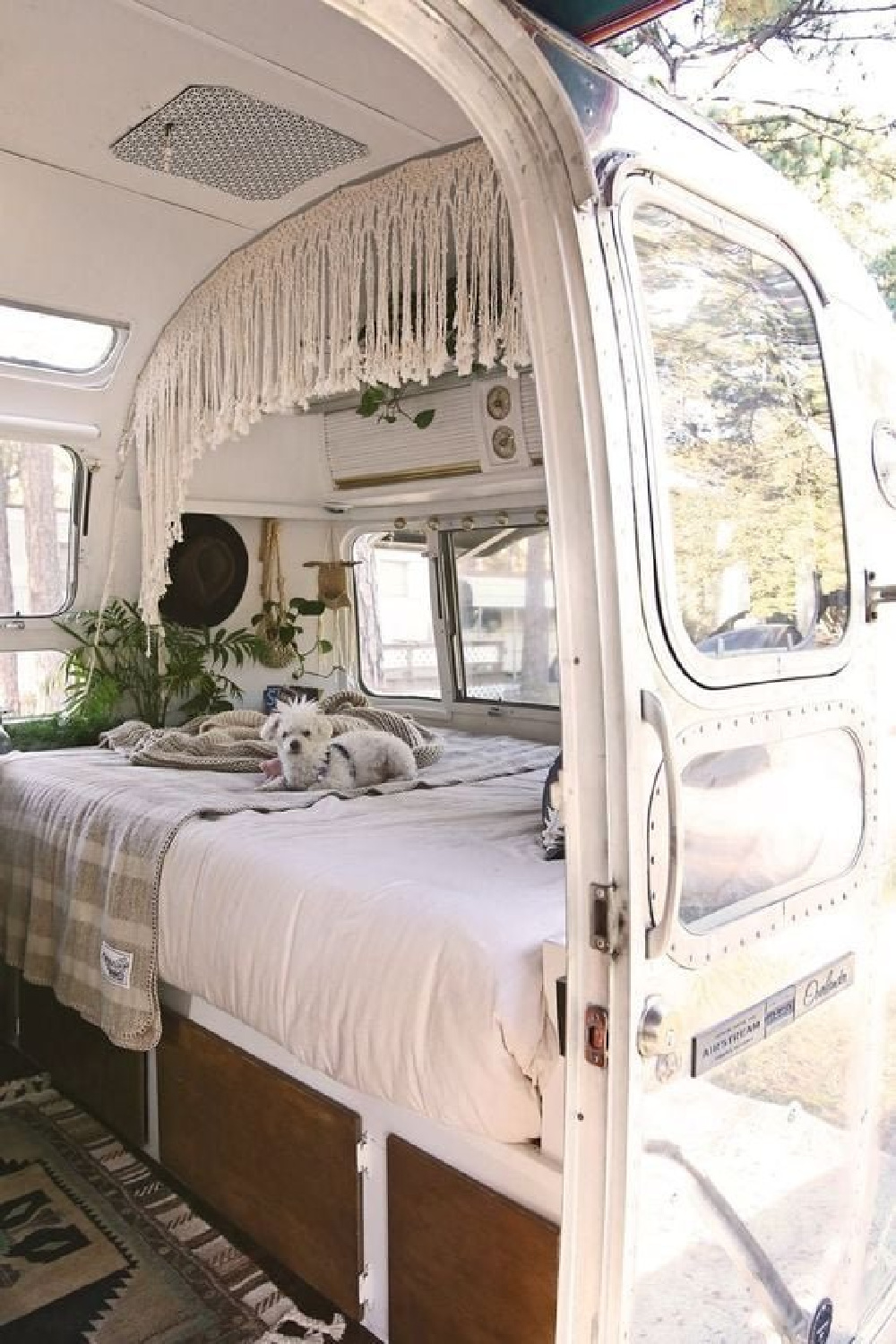 Vintage Airstream with a little white dog inside on the bed - via A Humble, Simple Life. #vintagecampers #airstream