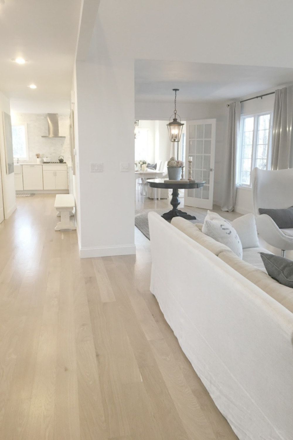 Hello Lovely Studio's white oak hardwood floors in her European country living room, dining, and kitchen with Belgian linen. #hellolovelystudio #interiordesign #whiteoak #hardwoodfloors #belgianlinen #europeancountry #openfloorplan