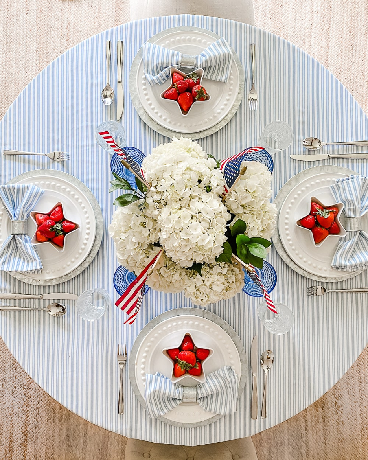 Beautiful 4th of July tablescape by The Diary of a Debutante with star dishes layered on light blue. #4thofjuly #redwhiteandbluetablescapes