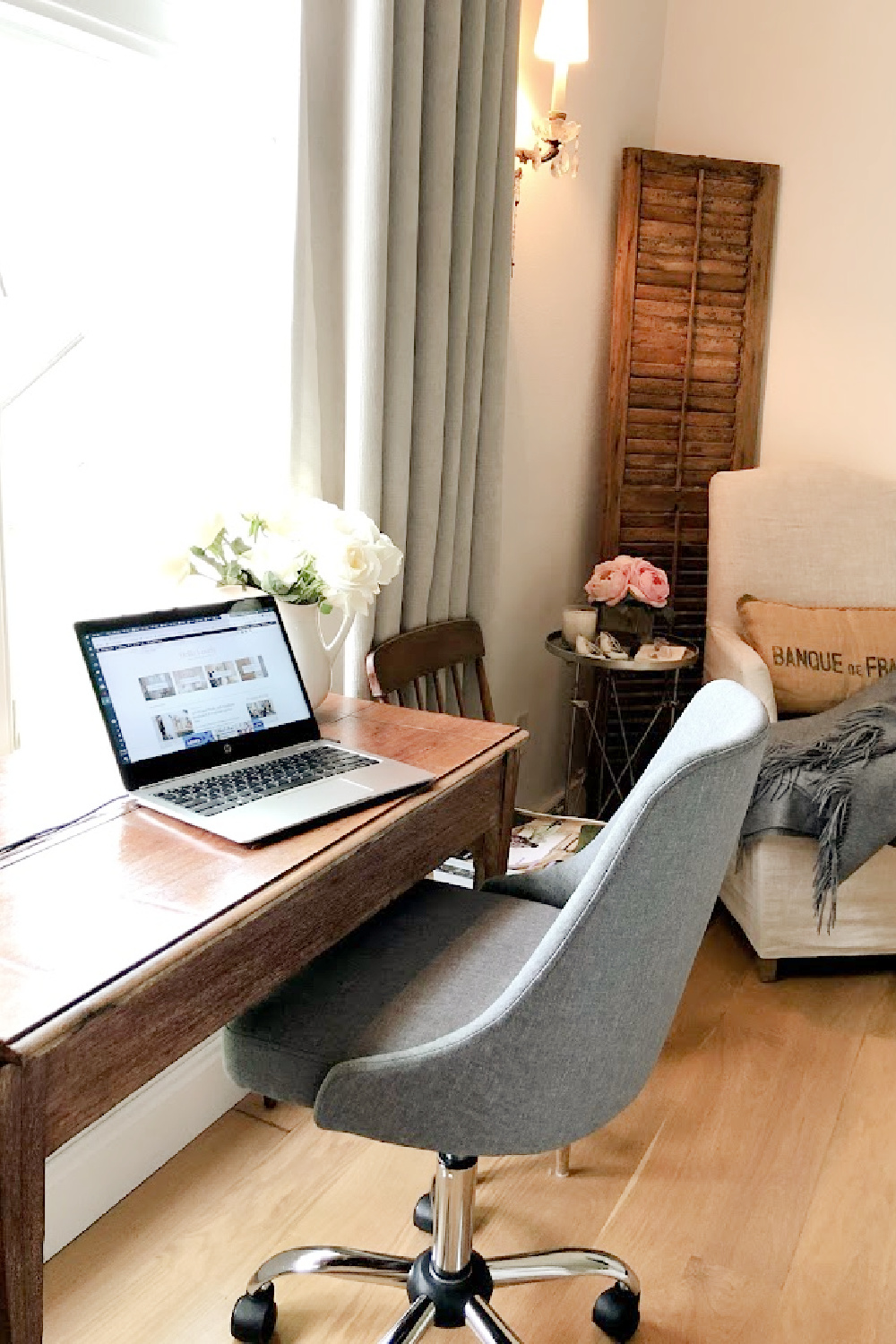 Chic grey upholstered desk chair with antique desk in our French country bedroom - Hello Lovely.