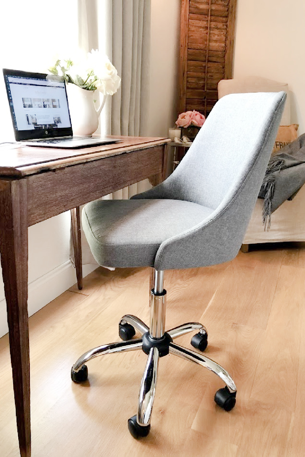 Chic grey upholstered desk chair with antique desk in our French country bedroom - Hello Lovely.