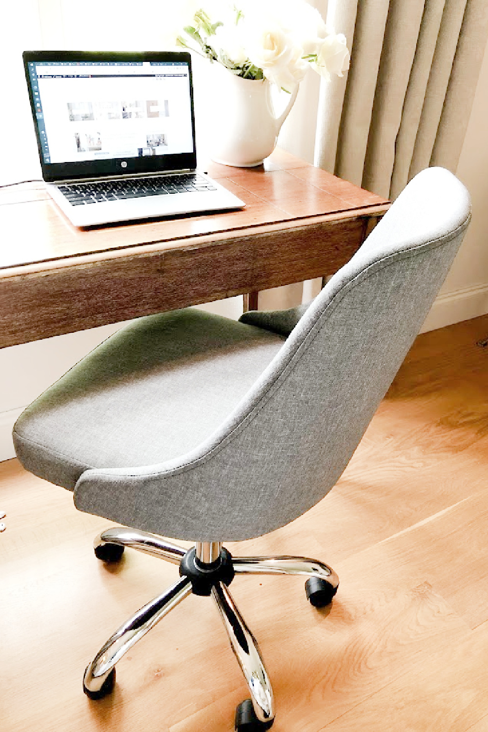 Chic grey upholstered desk chair with antique desk in our French country bedroom - Hello Lovely.