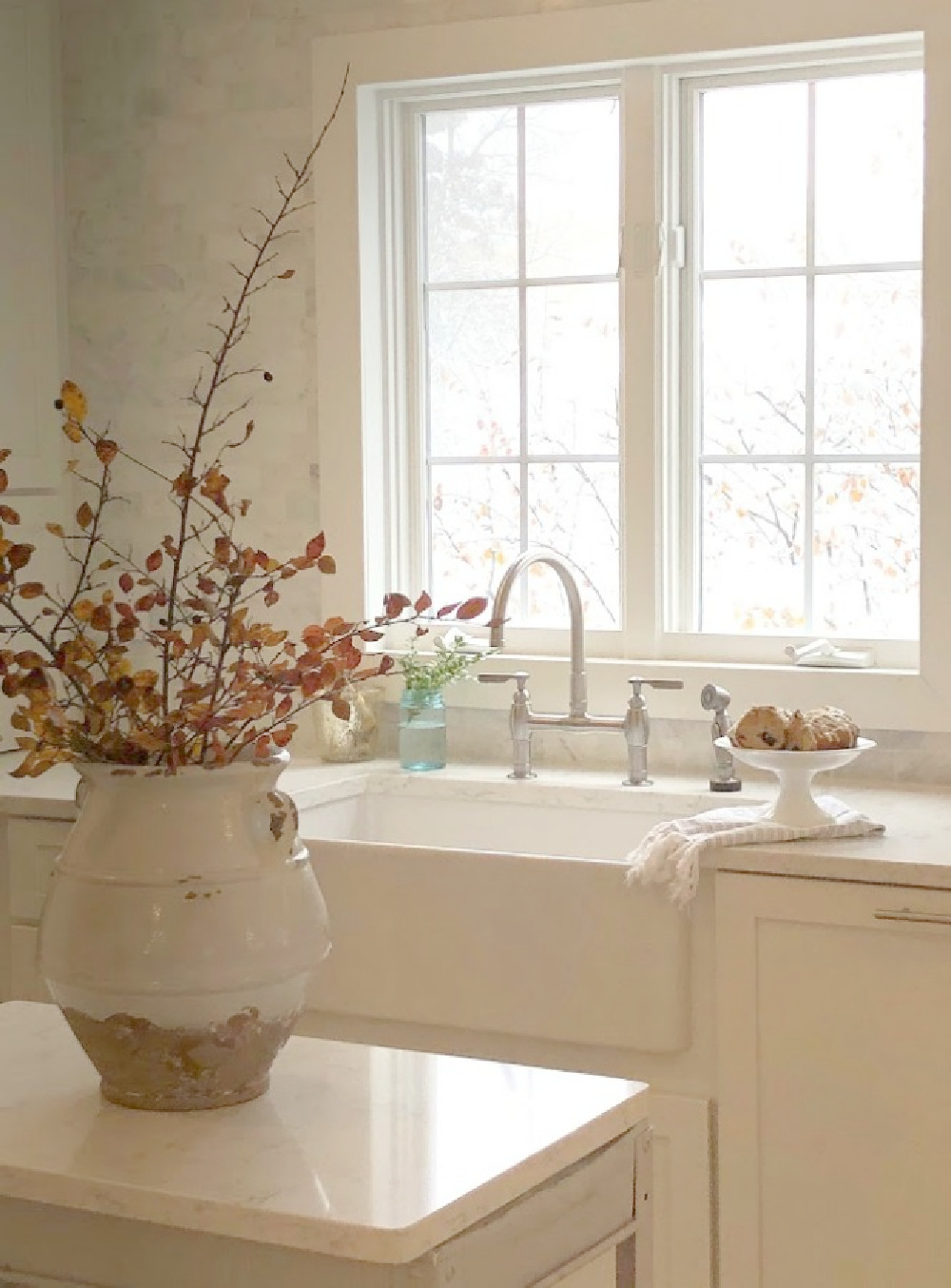 Shaker style white cabinets in simple serene kitchen with white oak floors and Viatera Minuet quartz countertops - Hello Lovely Studio.