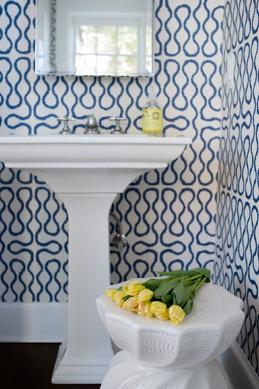 Whimsical blue and white bold wallpaper in a bathroom with pedestal sink. Blue and White Classic Decor Inspiration: Ella Scott Design. #blueandwhitebath #bluewallpaper 
