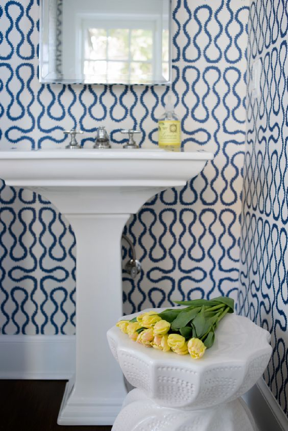 Whimsical blue and white bold wallpaper in a bathroom with pedestal sink. Blue and White Classic Decor Inspiration: Ella Scott Design. #blueandwhitebath #bluewallpaper