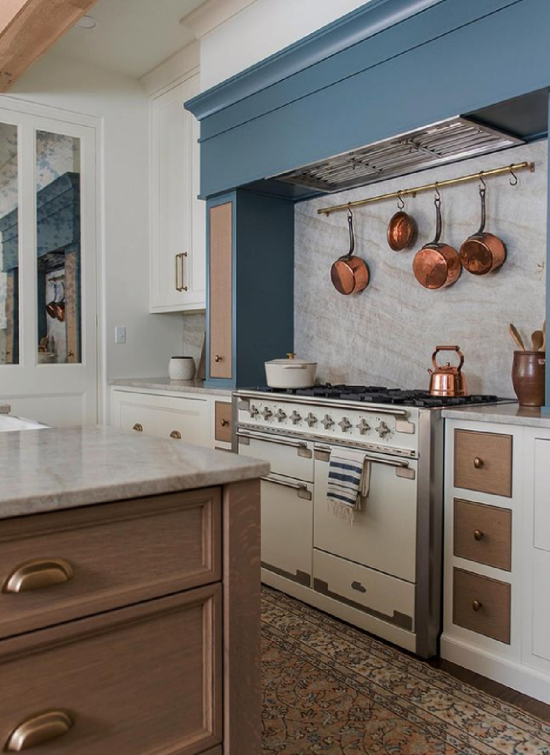 Traditional French country kitchen with blue painted range hood, French range, and copper pots - Whittney Parkinson. #frenchkitchens #bluekitchens
